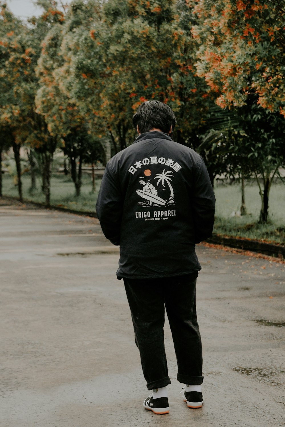 man in black hoodie walking on road during daytime