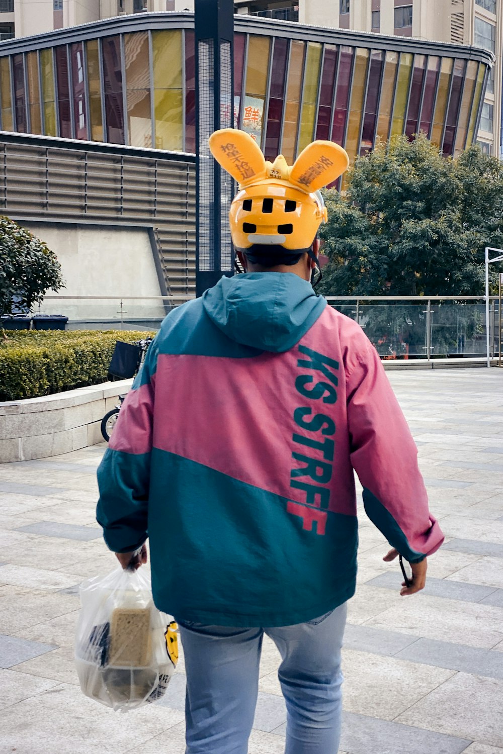 a person wearing a bunny ears hat walking down the street