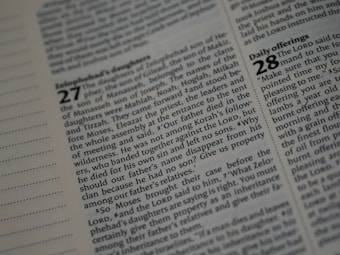A close-up view of a page from a book showing columns of printed text. The page includes numbered sections, highlighting certain words in bold. The layout appears to be organized similarly to a religious or academic text.