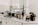 A laboratory workspace featuring a variety of equipment including a microscope, other analytical devices, and shelves with bottles and laboratory supplies. The room is organized and well-lit with clean surfaces and cabinetry.