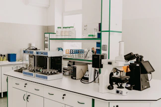 A laboratory workbench with a microscope and analytical equipment in a bright room