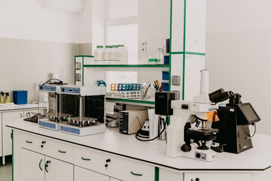 A sleek laboratory setup featuring microscopes, test tubes, and analytical instruments arranged neatly on a modern bench.