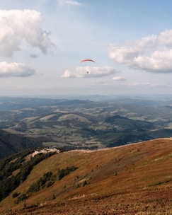 A breathtaking view of paragliding over the hills.
