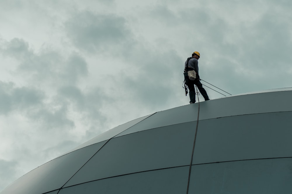 man in black jacket and black pants standing on top of building