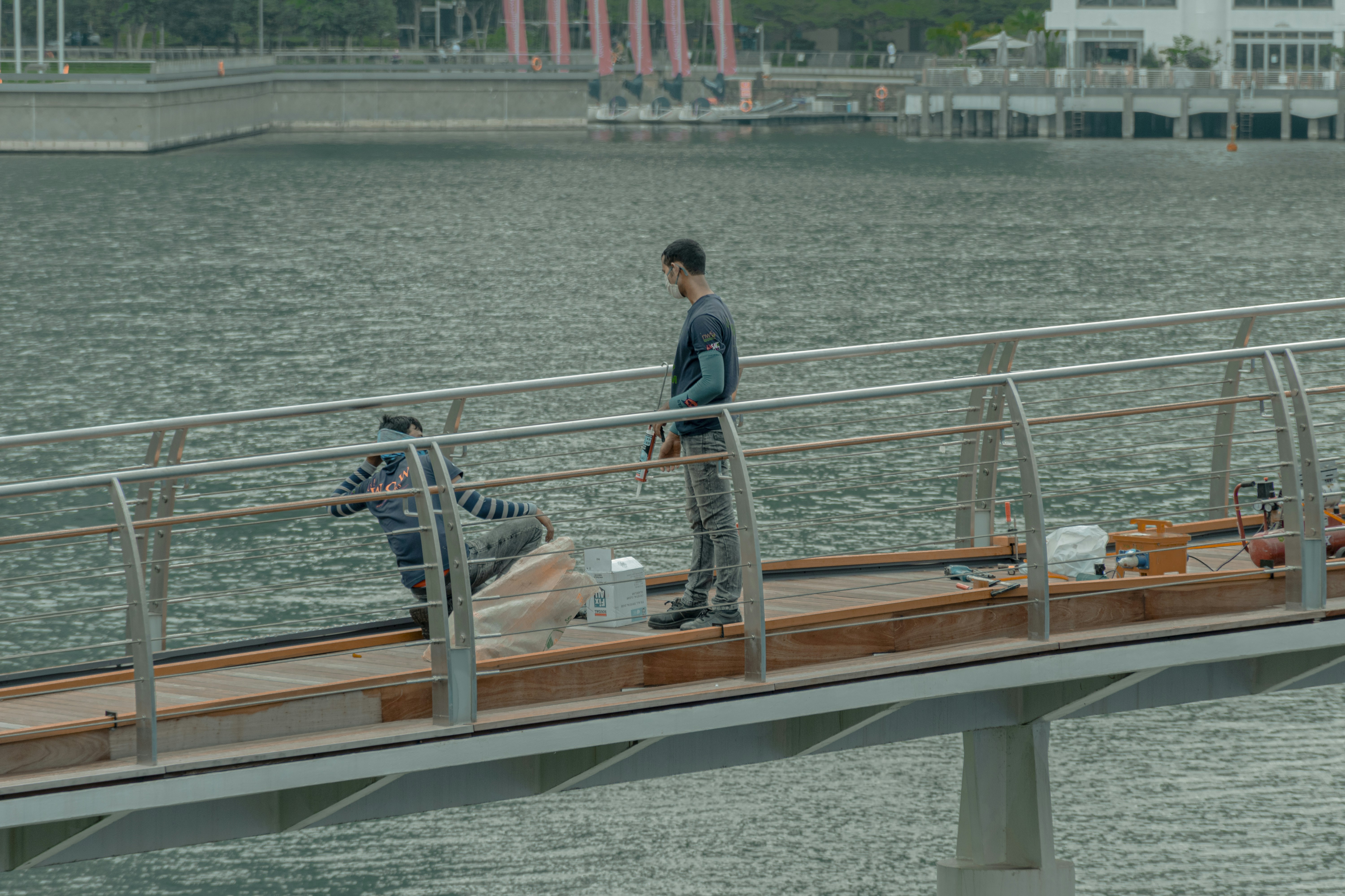 man in blue denim jacket standing on brown wooden dock during daytime