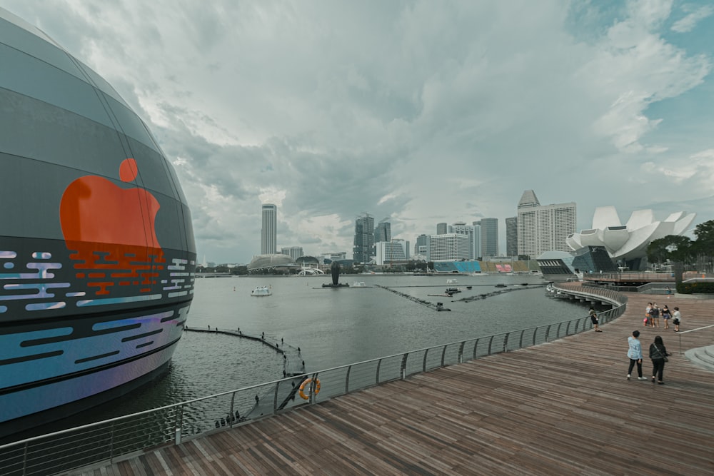 orange and blue ship on dock near city buildings during daytime