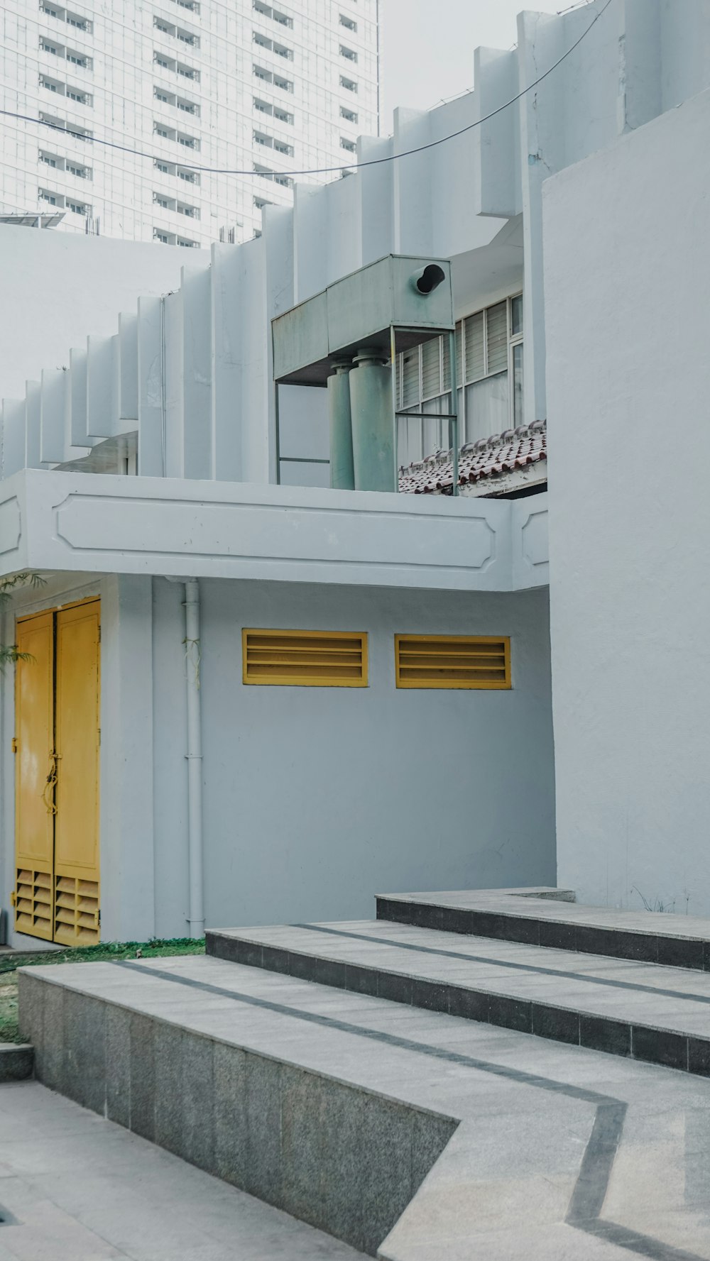 white concrete building with yellow door