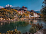 a large building sitting on top of a hill next to a river