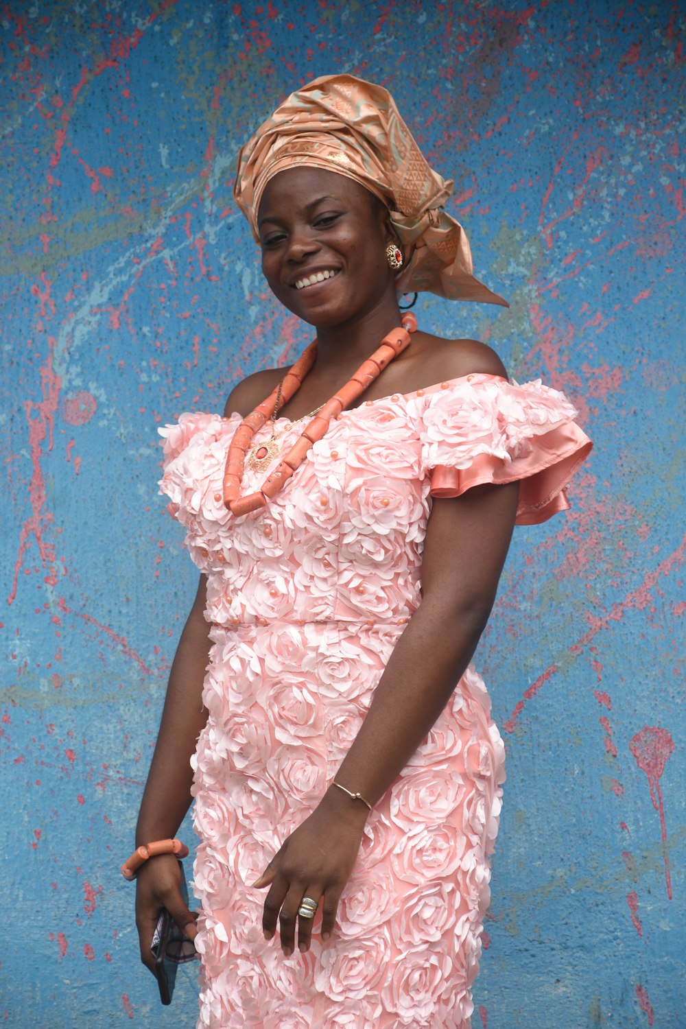 Femme en robe blanche à fleurs appuyée sur le mur