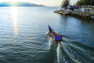 Passengers enjoying a calm boat ride with vibrant local scenery in the background.