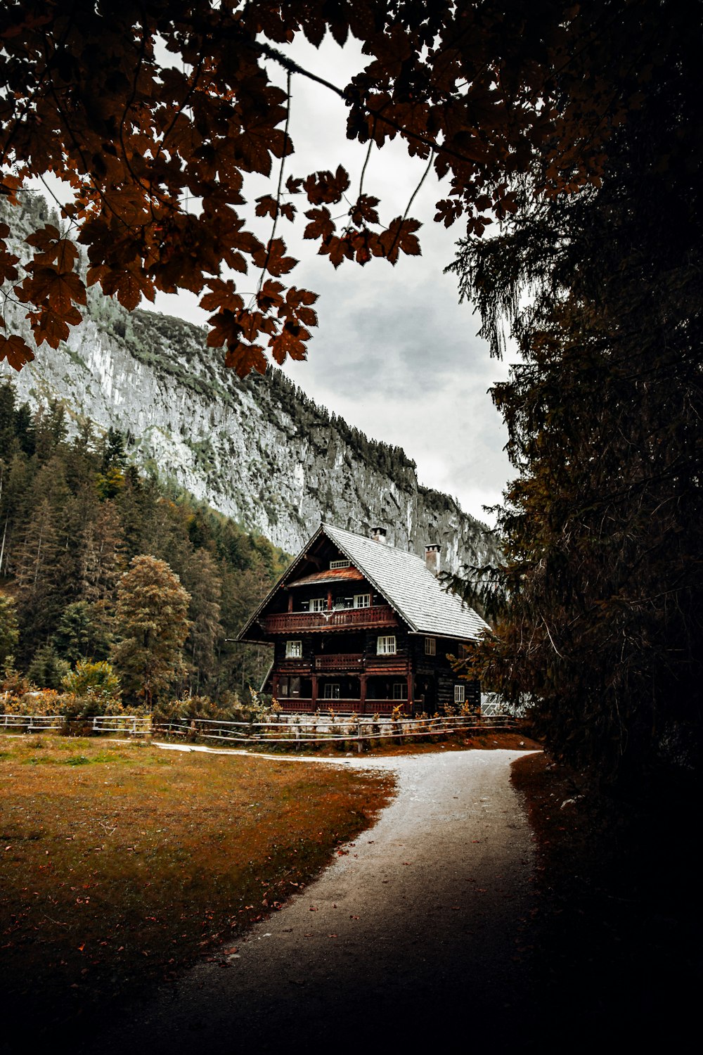 brown wooden house near green trees and mountain during daytime