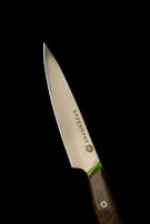 A sleek, sharpened knife with a polished metallic blade and a dark wooden handle, set against a stark black background. The knife has the brand name Savernake inscribed on it, and there is a green accent between the blade and handle.