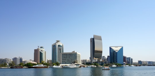 city skyline across body of water during daytime in Dubai Creek United Arab Emirates