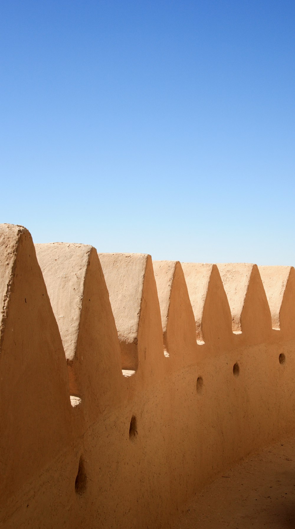 brown concrete wall under blue sky during daytime