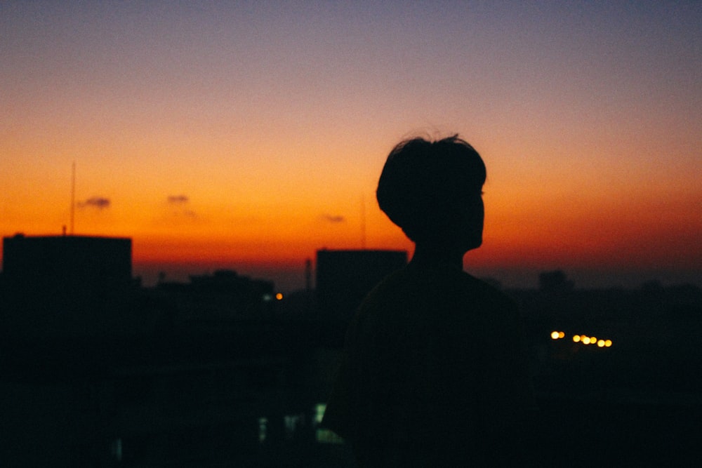 silhouette of man standing during sunset