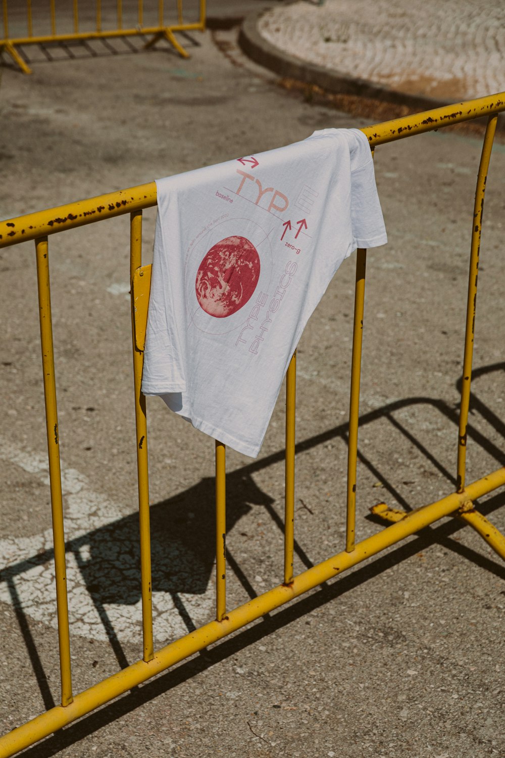 white and red textile on yellow metal fence