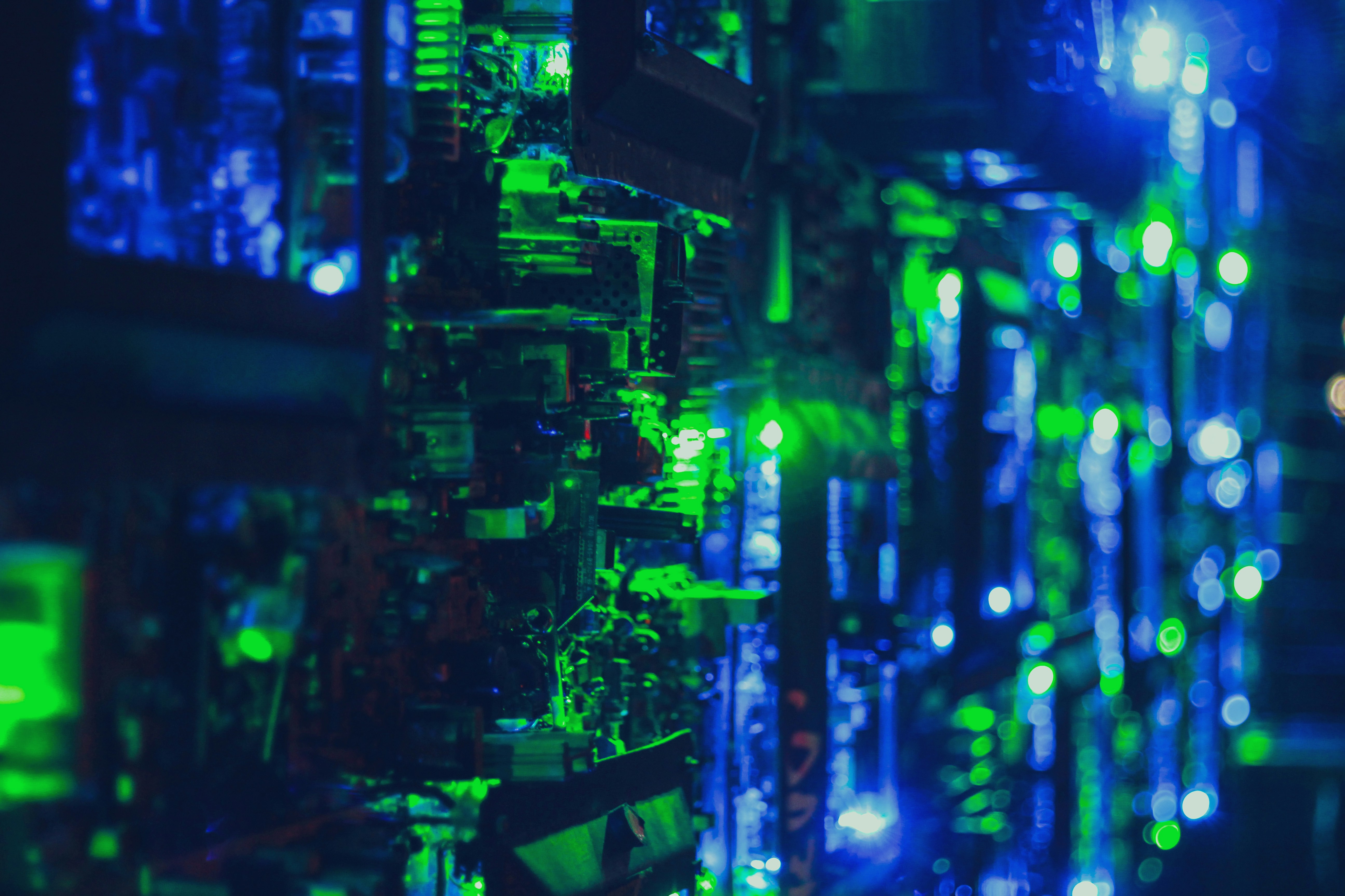 Circuit board close-up with dim blue-green ambient lighting, dark background, technological atmosphere, moody industrial lighting
