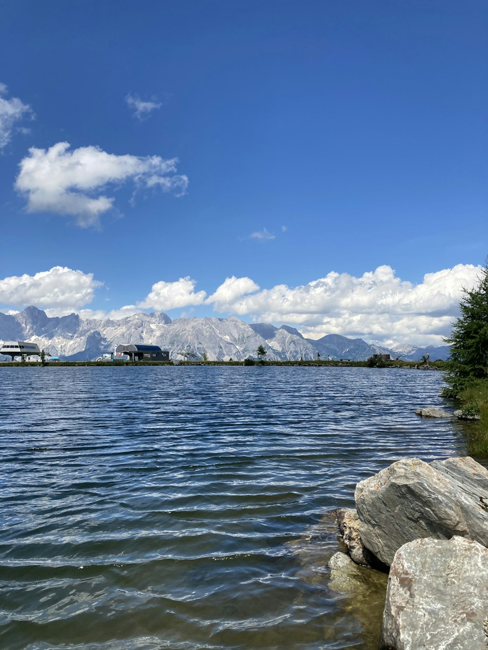 body of water near green trees under blue sky during daytime