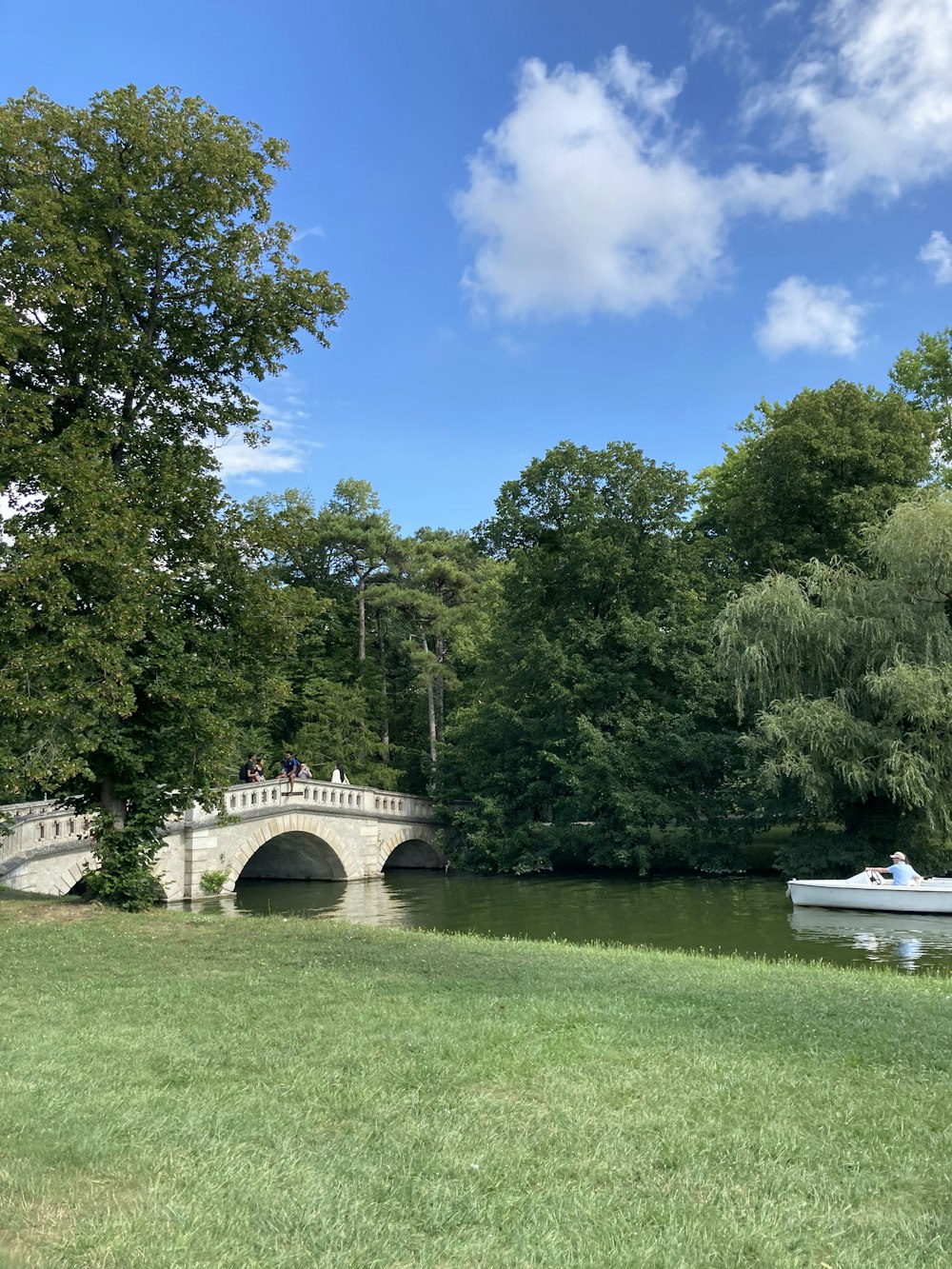 white boat on river under bridge