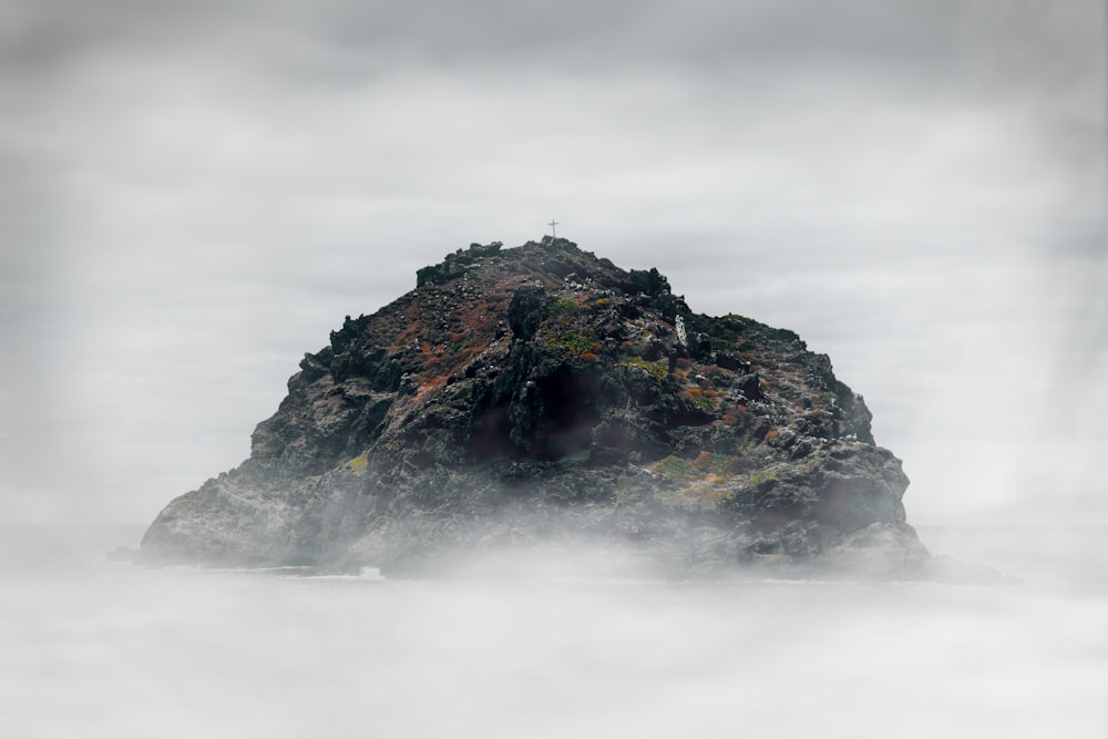 green and black rock formation under white clouds during daytime