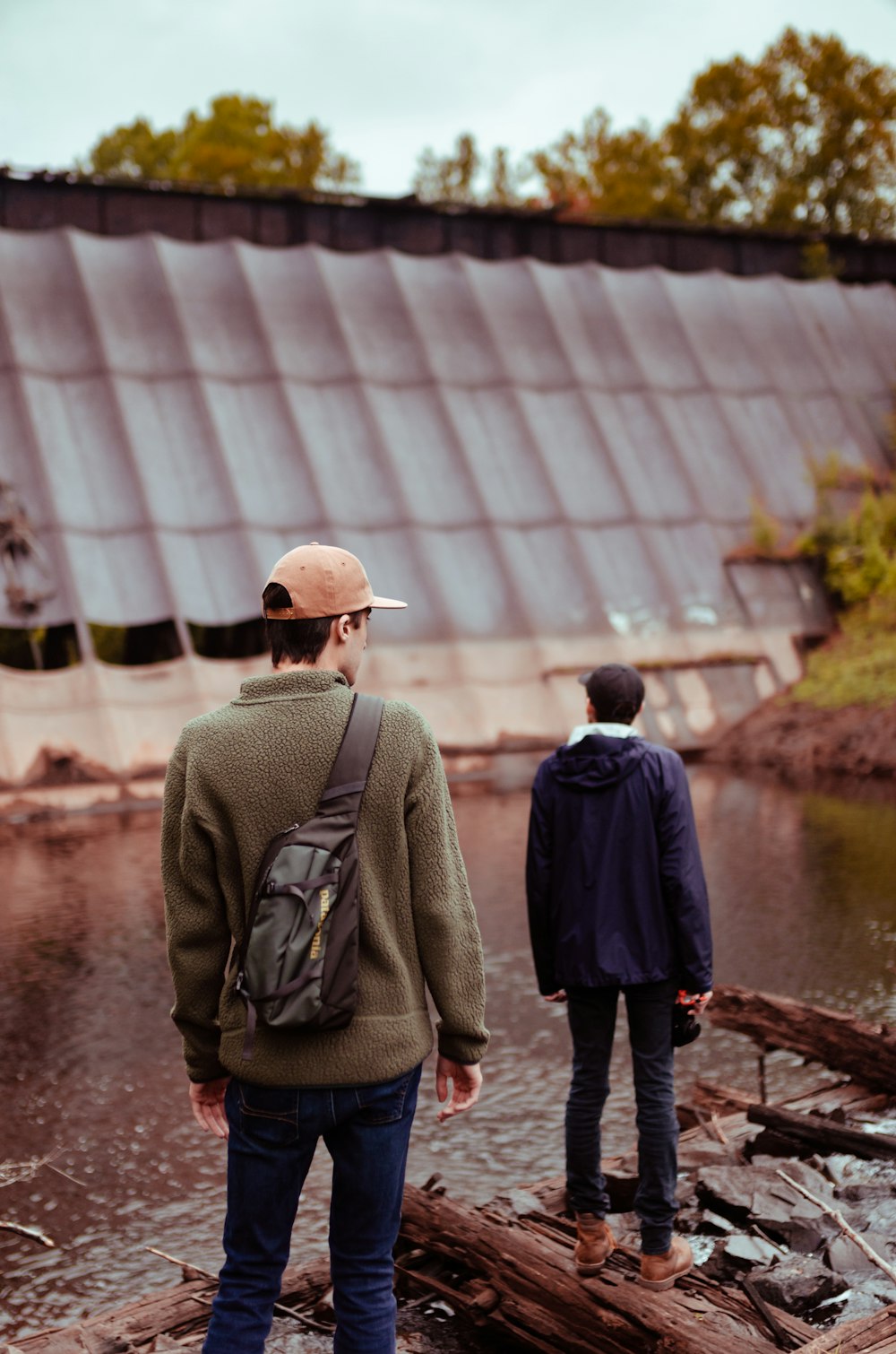 man in gray jacket standing near body of water during daytime