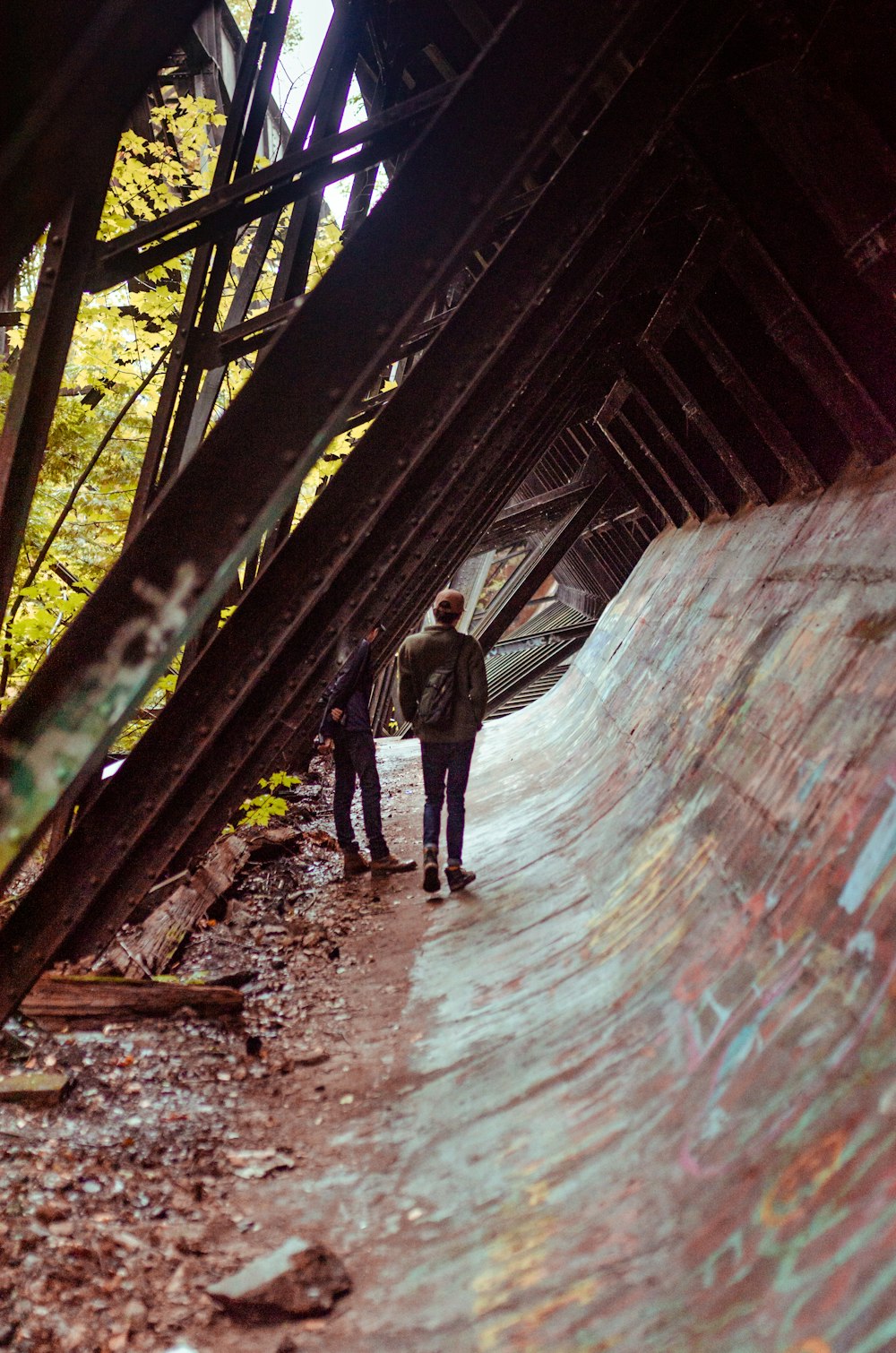 man in black jacket and pants walking on tunnel during daytime