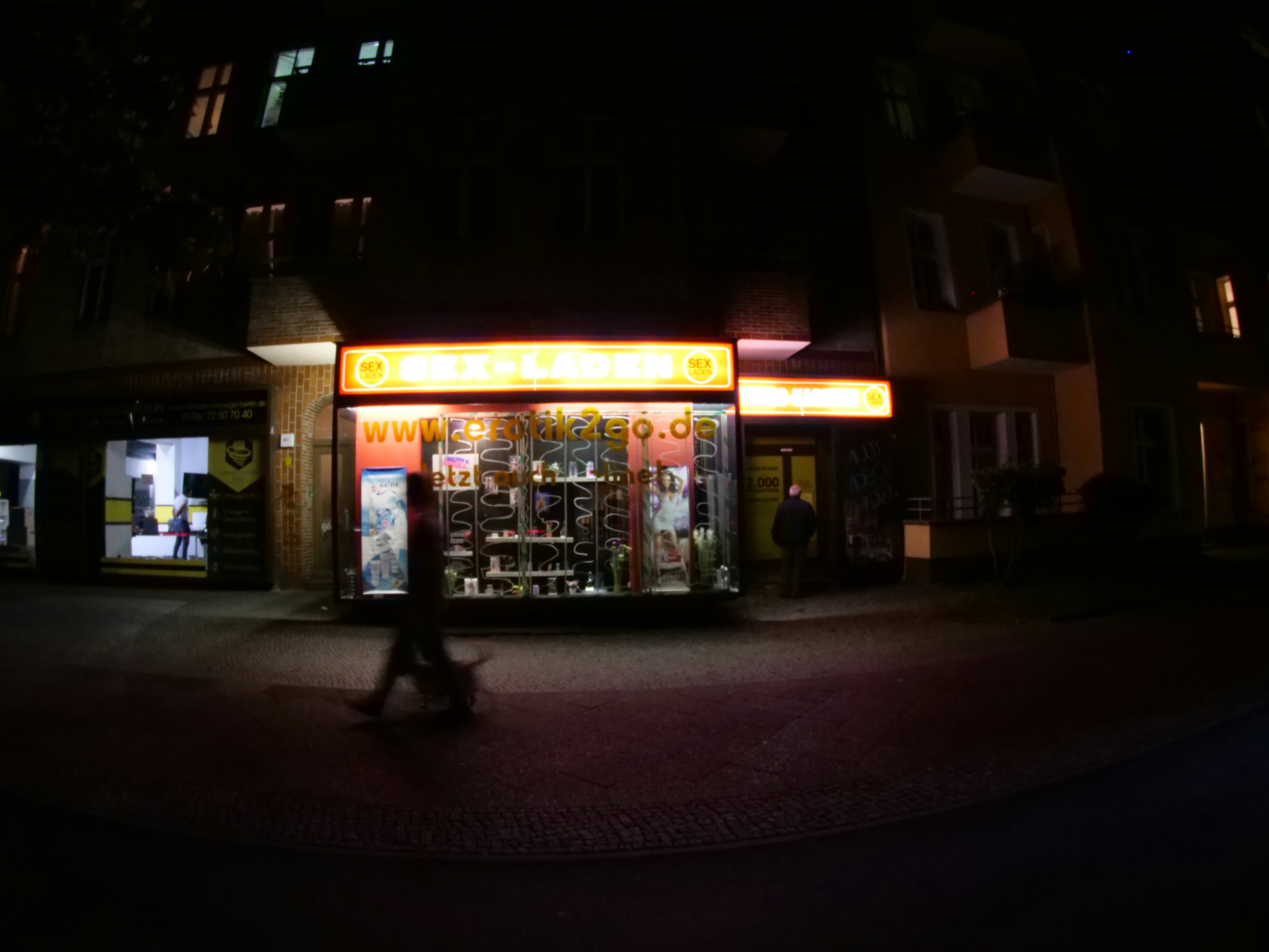 people walking on sidewalk near store during night time