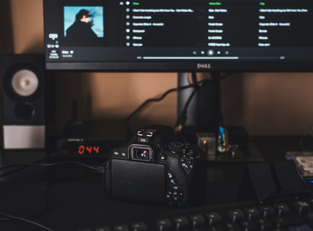 black canon dslr camera on black computer keyboard