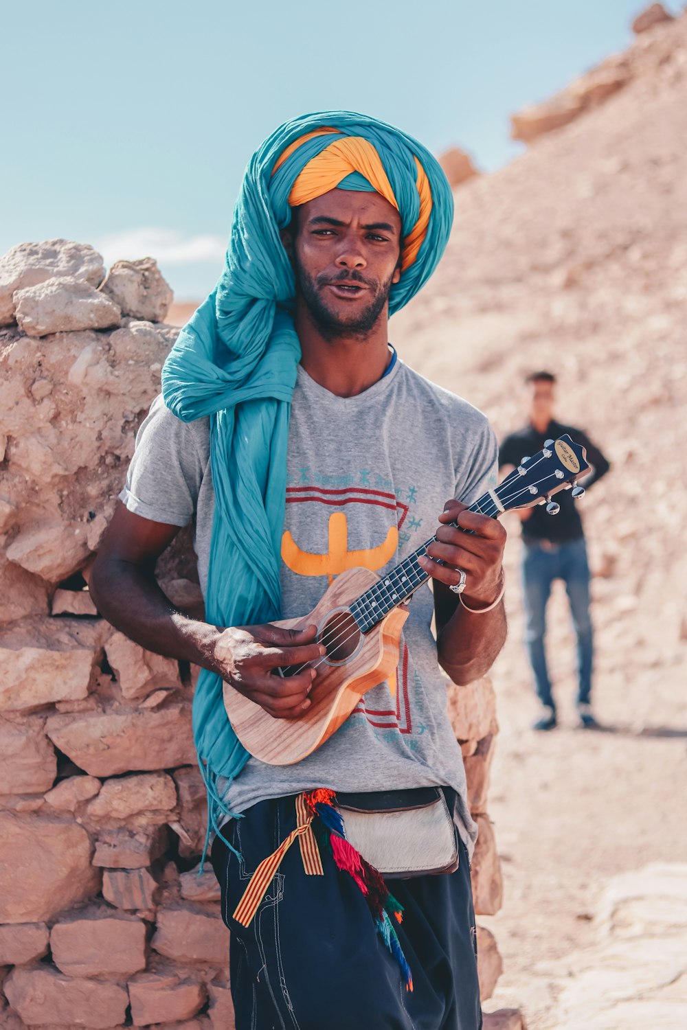茶色のアコースティックギターを持つ青いヒジャーブの女性