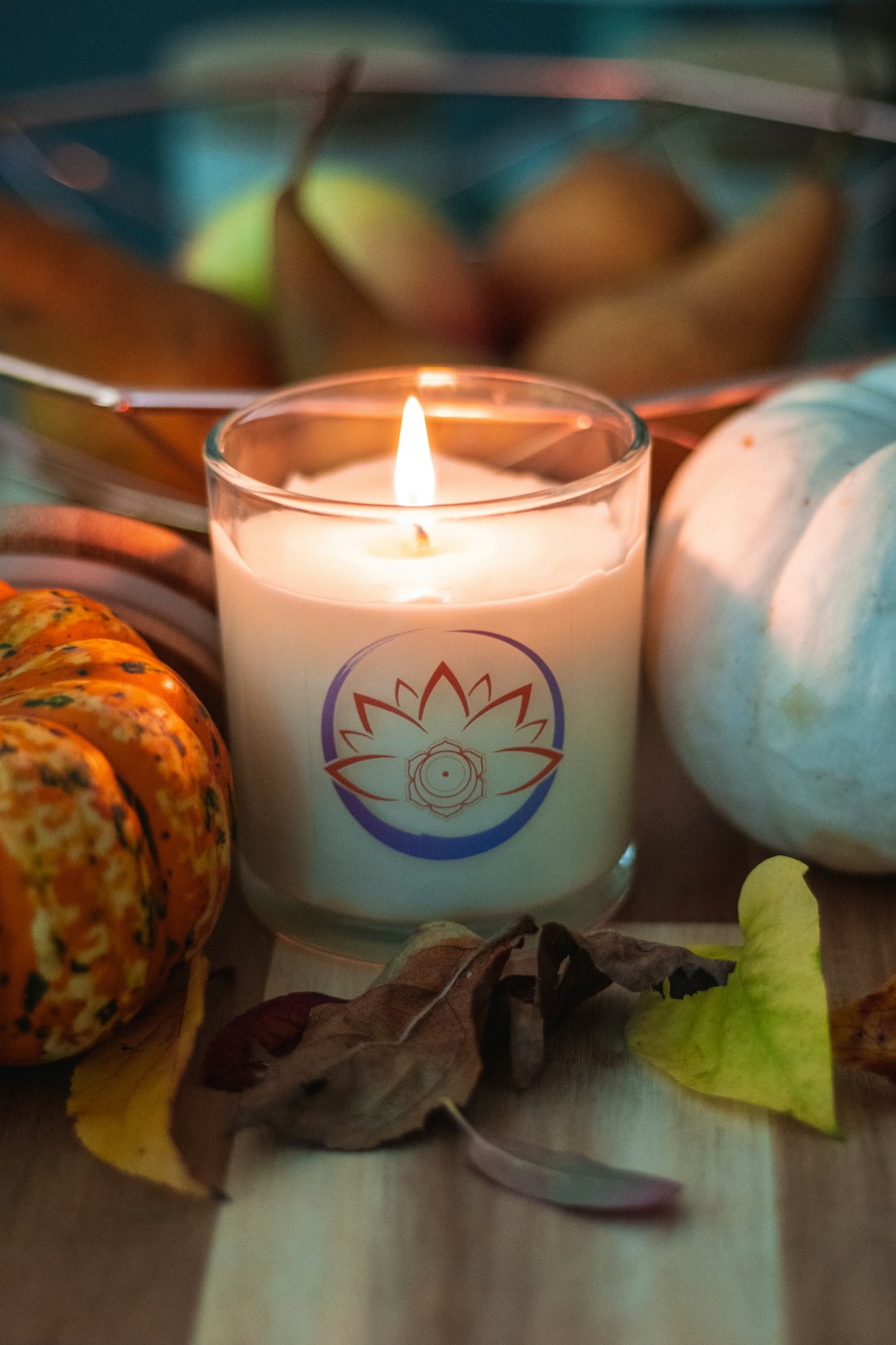 white pillar candle beside orange and white pumpkin