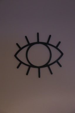 Black and white minimalist illustration of an eye with circular shapes surrounding it, reflecting the Metastasis Club logo.