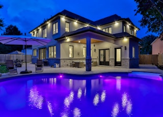 white concrete building near swimming pool during night time