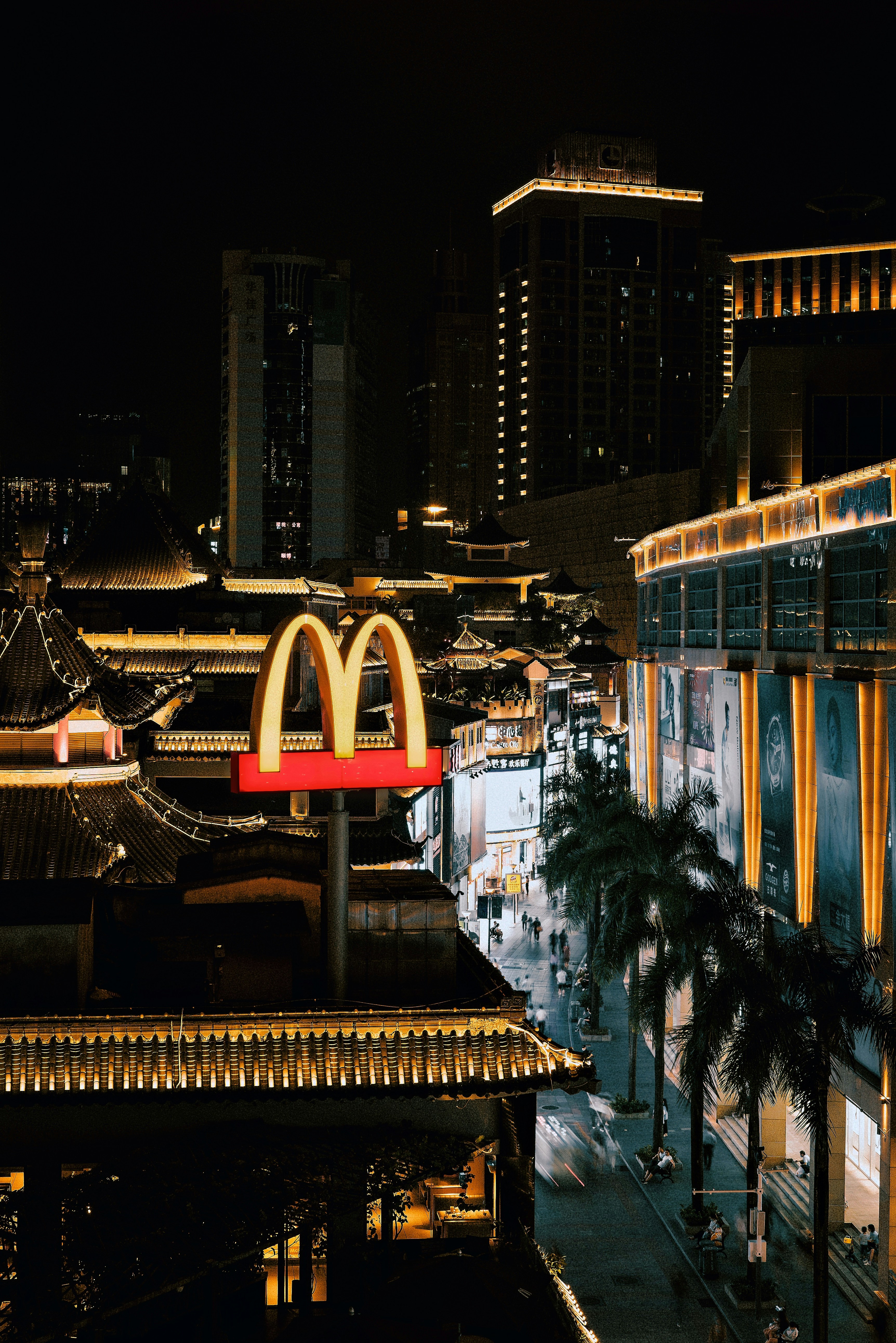 people walking on sidewalk near building during night time