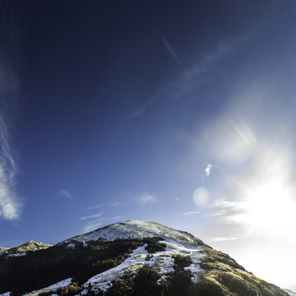 montanha coberta de neve sob o céu azul durante o dia