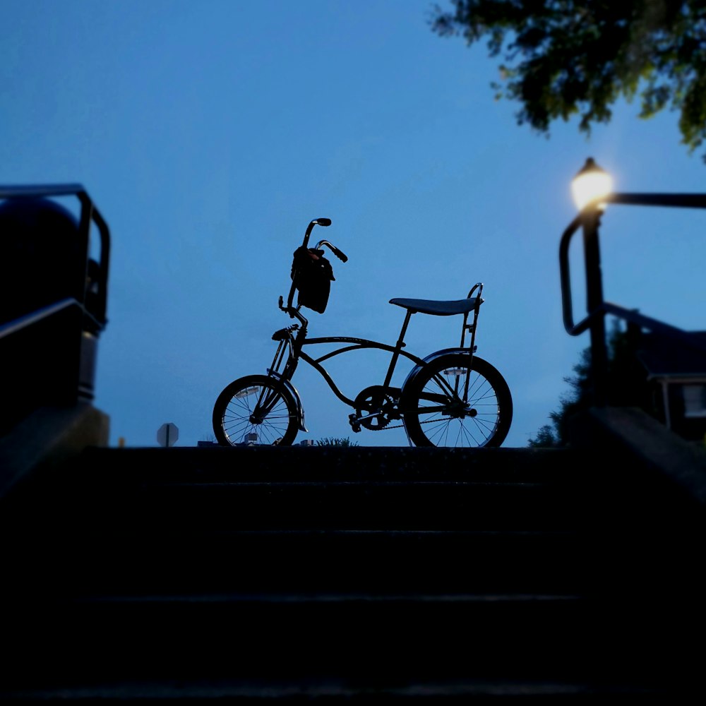 silhouette of man riding bicycle during sunset