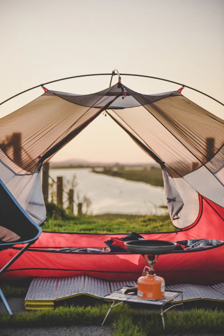 red and white tent on green grass field during daytime