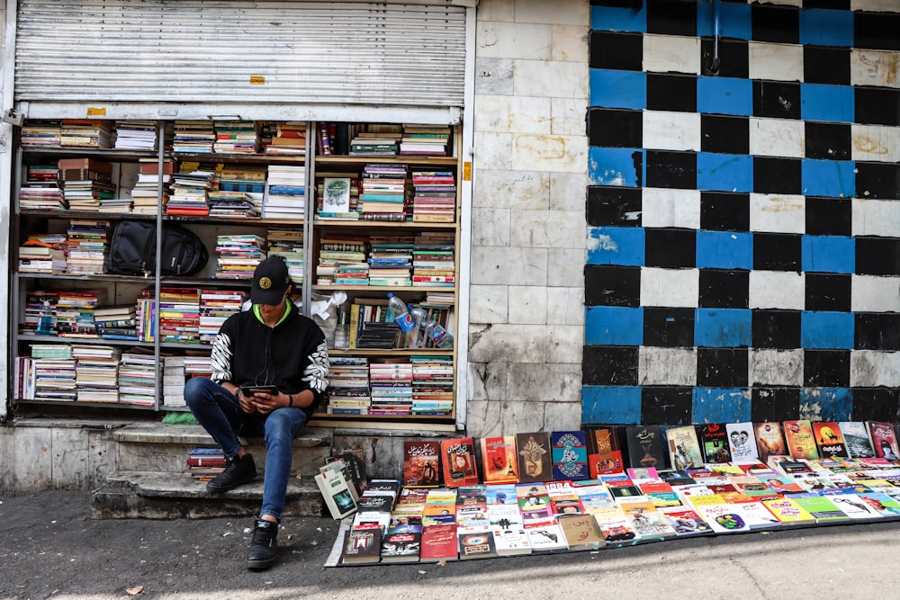 man in black long sleeve shirt sitting on books