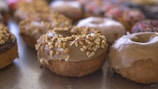 Close-up of a colorful assortment of Smithfield Ave Donuts neatly arranged in a rustic box.