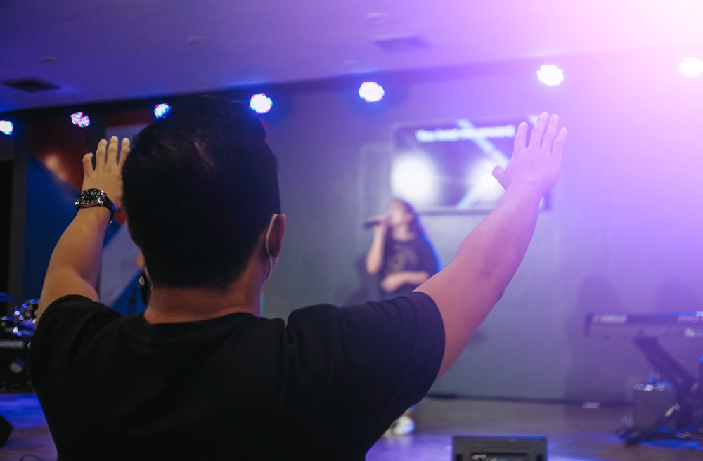 man in black long sleeve shirt raising his hands