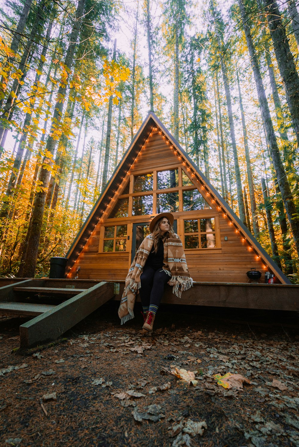 woman in brown coat standing on brown wooden bridge