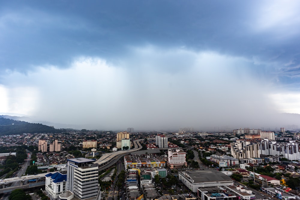 city with high rise buildings under white sky during daytime