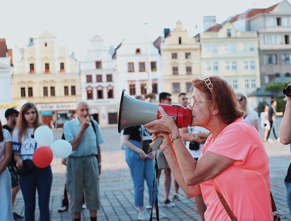 woman in pink shirt kissing man in black shirt during daytime