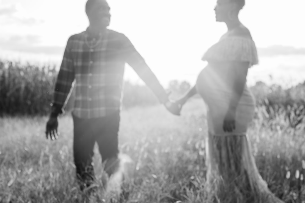 man in plaid shirt standing beside woman in white tank top