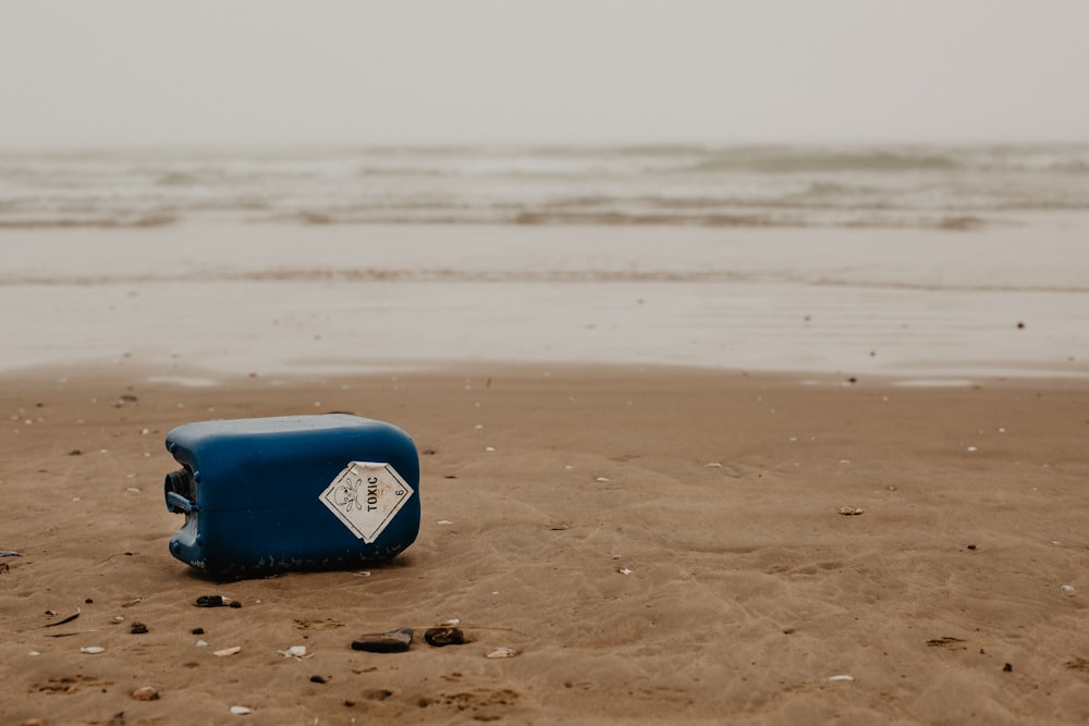 Tabla de surf azul y blanca en la playa durante el día