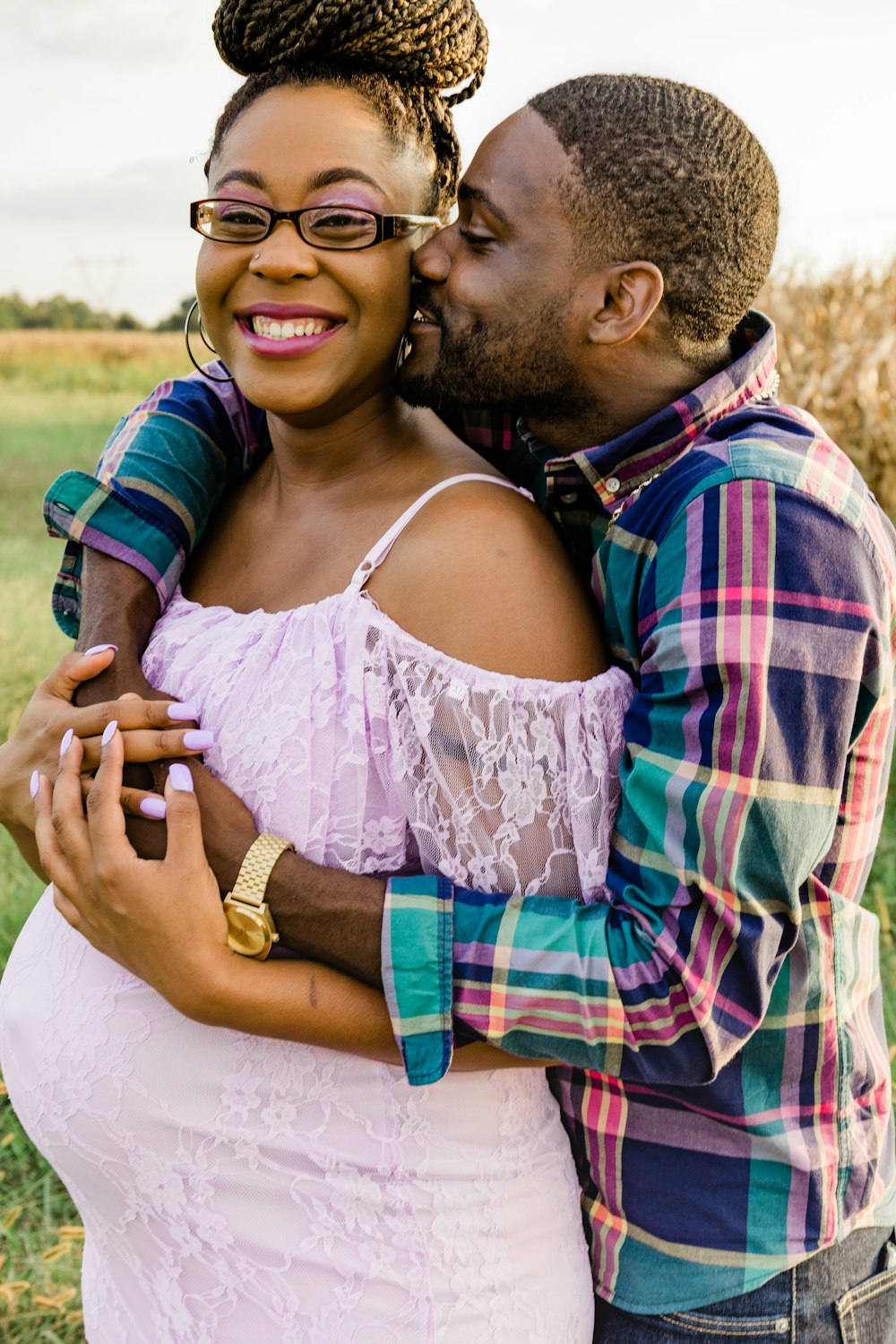 man in red blue and black plaid dress shirt kissing woman in white floral lace spaghetti