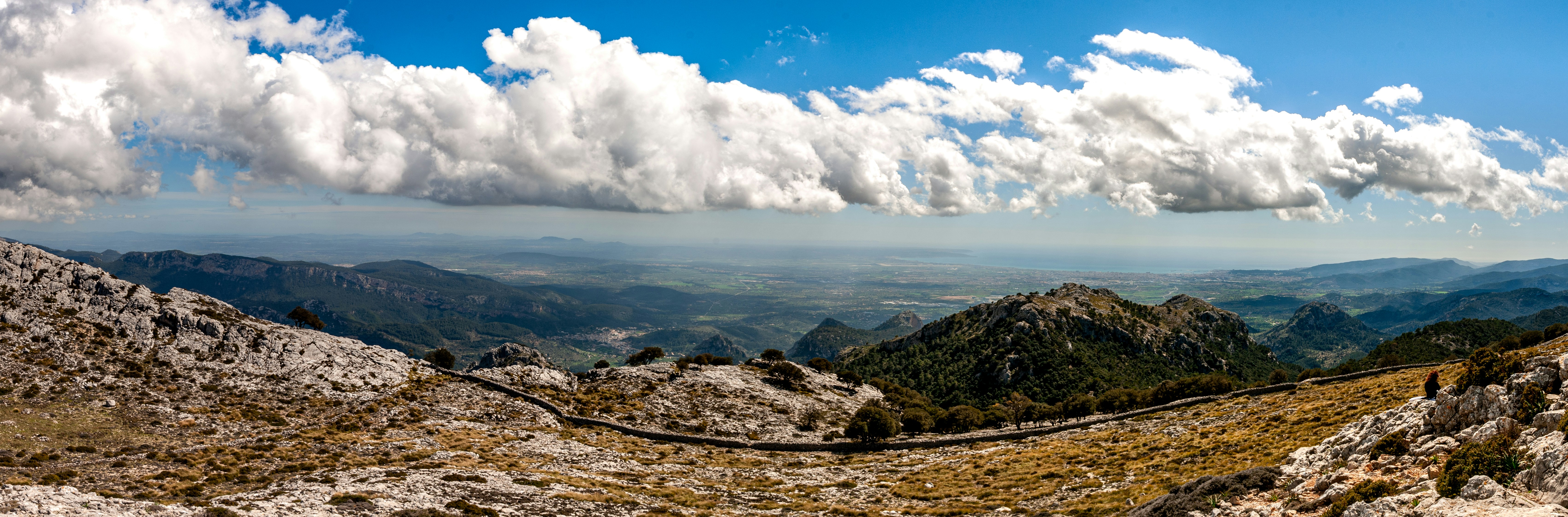 white clouds over brown mountains