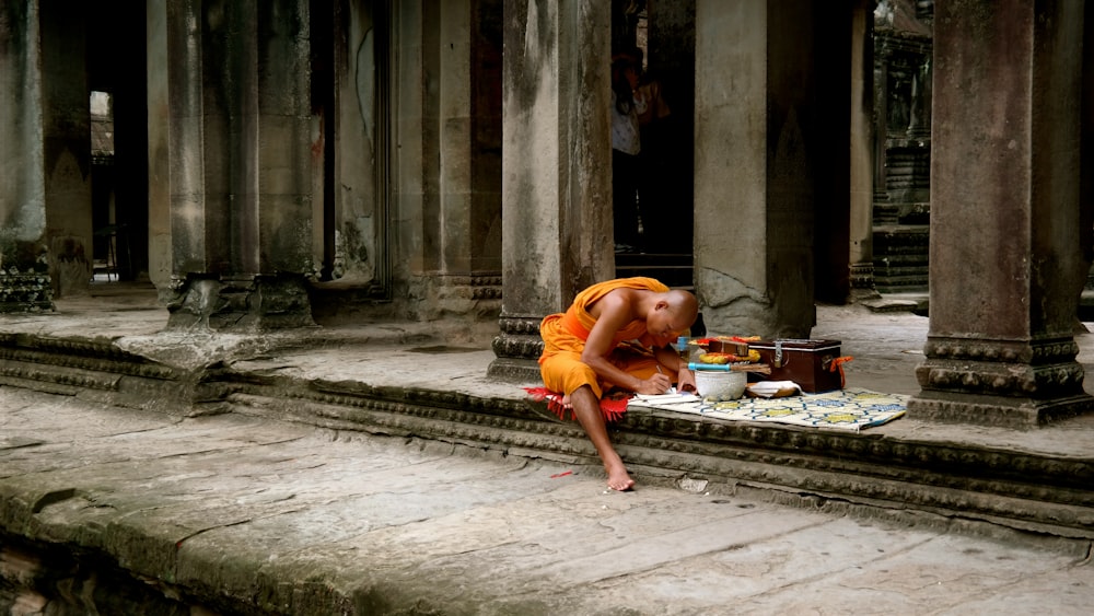 woman in orange dress lying on concrete floor
