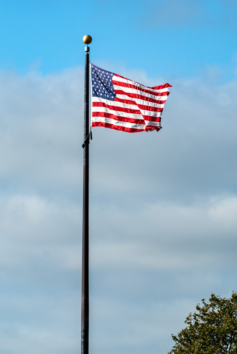 흐린 하늘 아래 기둥에 있는 미국 깃발