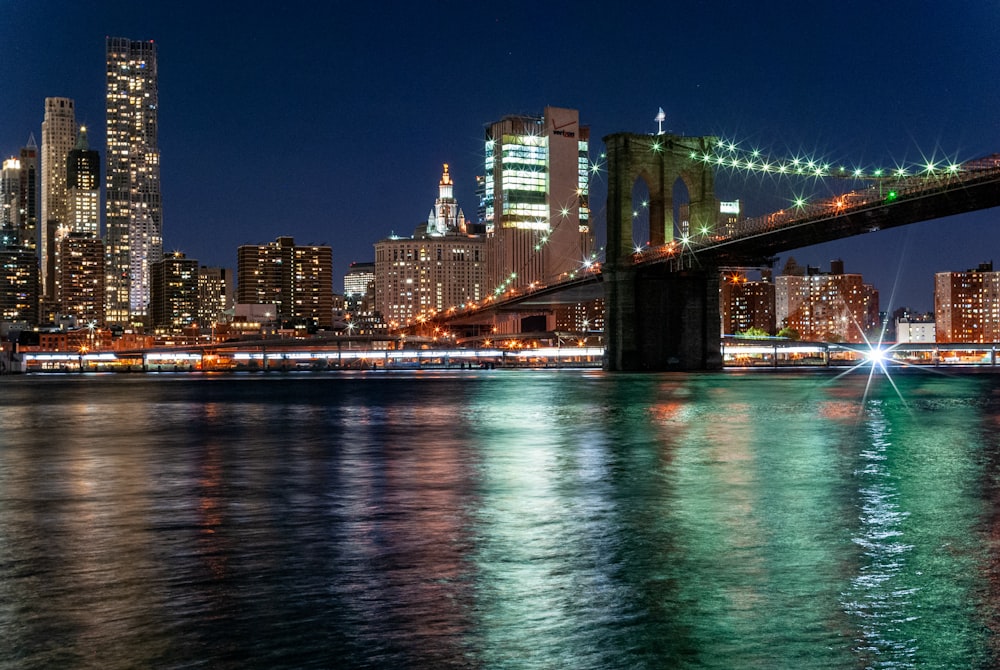 bridge over water near city buildings during night time