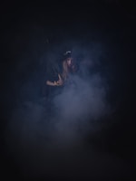 A mysterious shadowy figure lurking in a foggy alleyway at night.